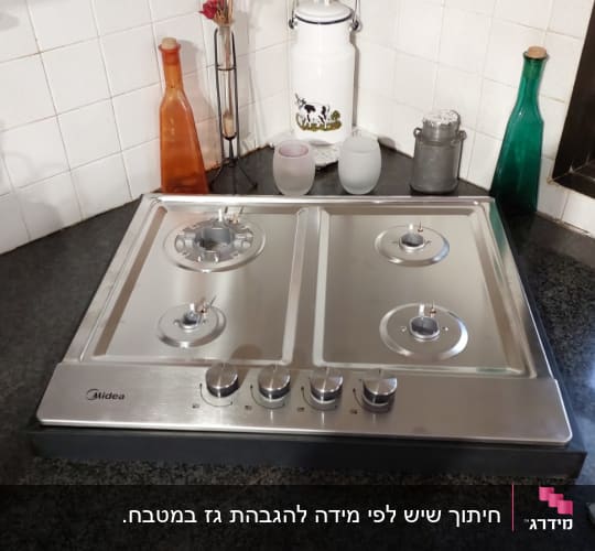 שיש כהה עם כיריים מנירוסטה במטבח